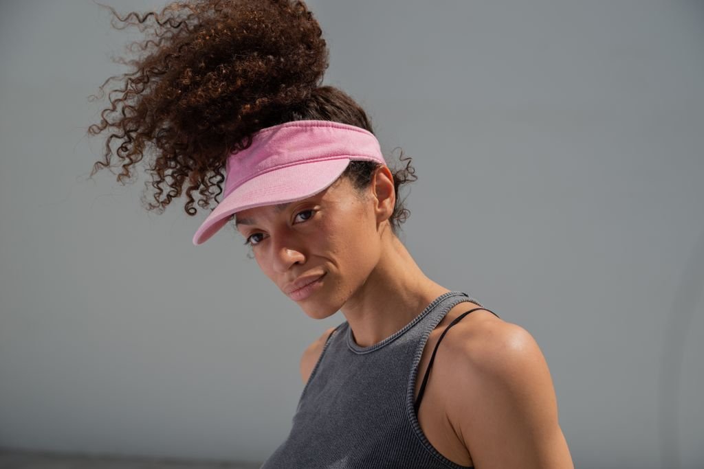 A girl with long hair wearing a visor cap.