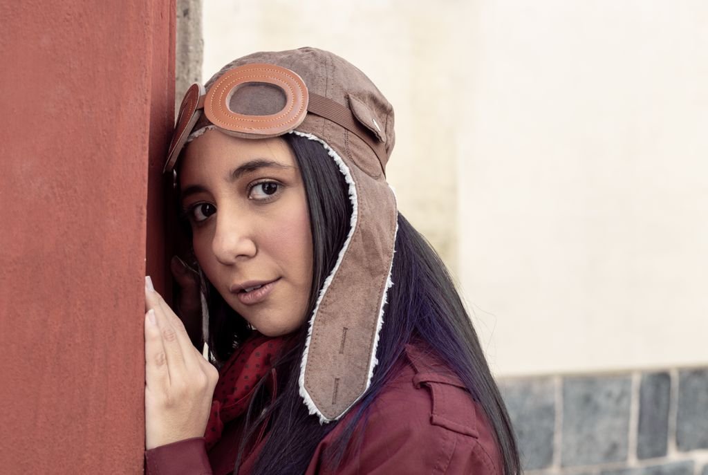 a young woman in an aviator hat